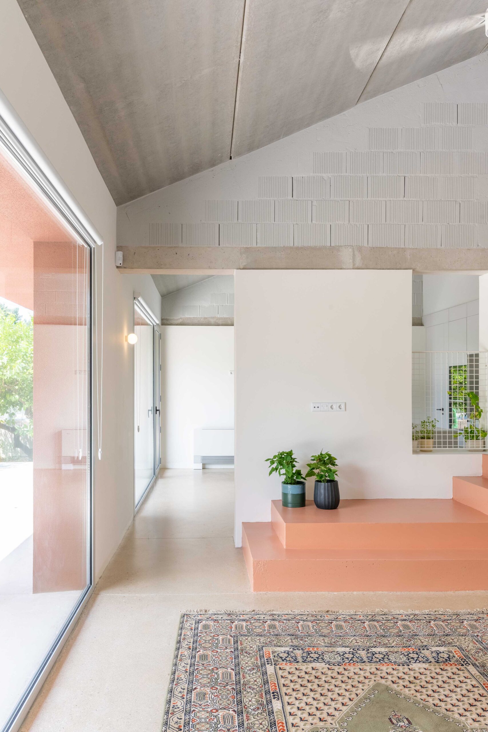 Salón con muros de fábrica confinada y techo de placas alveolares vistas.